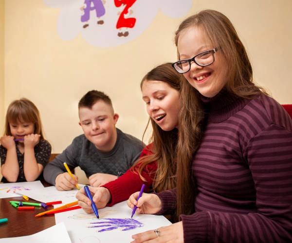 NDIS Group Activities: Children and teens drawing and coloring at a table