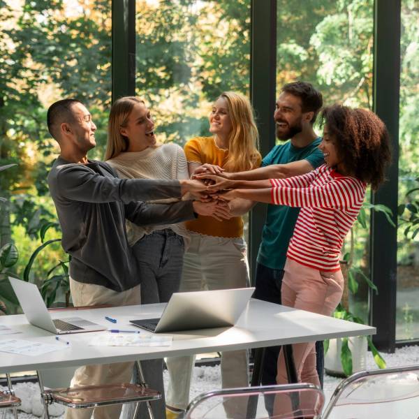 Diverse team celebrating success with hands stacked NDIS Community Access