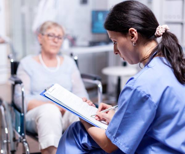 A young man and a carer work together on a document for Complex Care Services.
