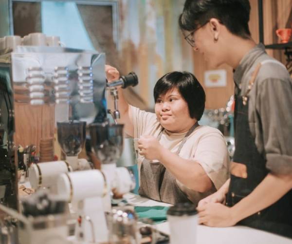 Support worker teaches coffee-making skills at a cafe - NDIS Life Skill Development